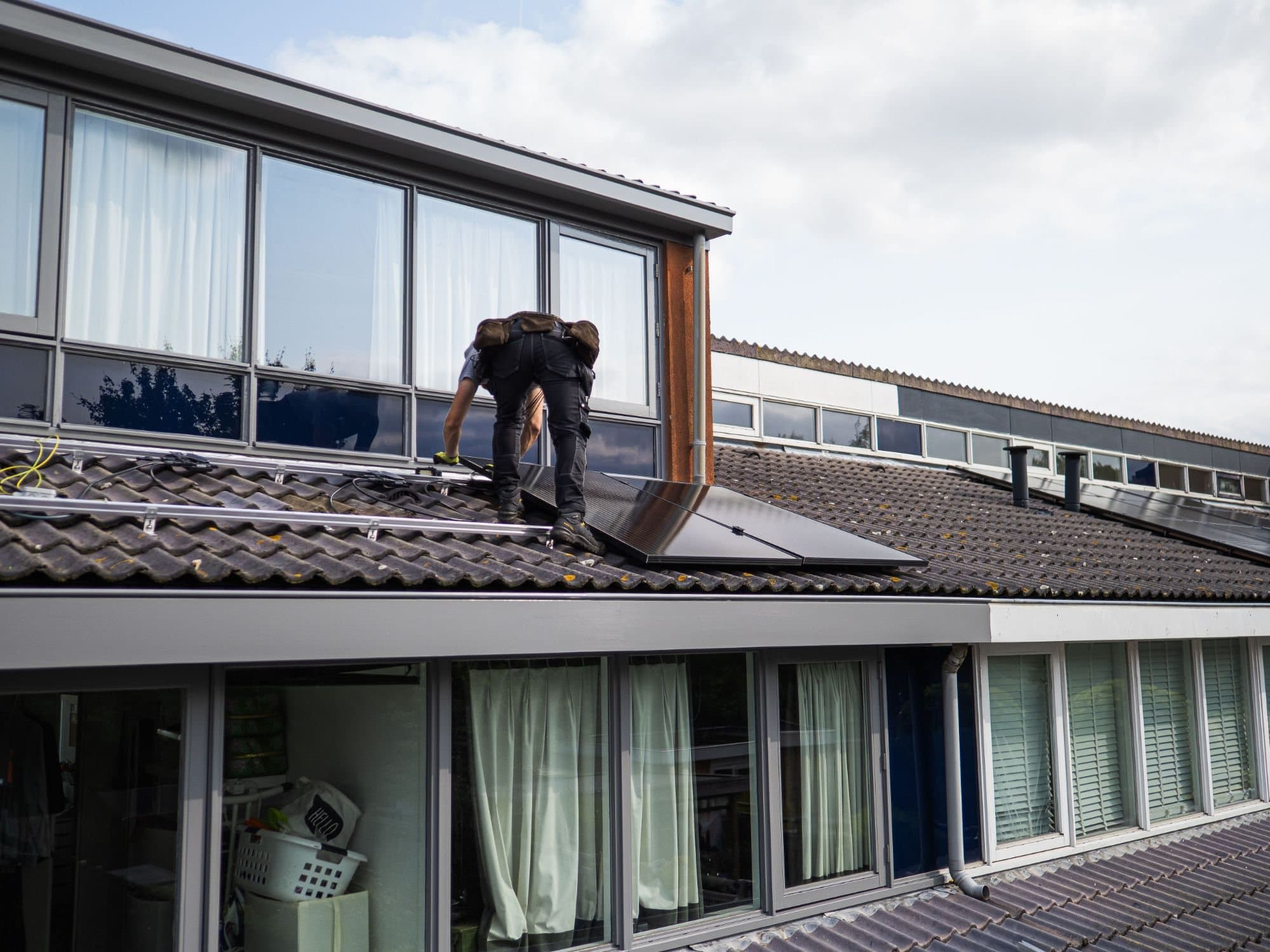 Monteur installiert Solarmodule auf einem Dach